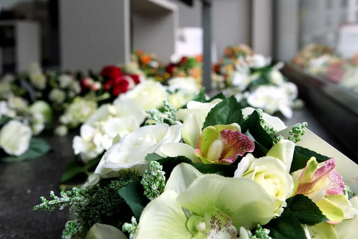 Kunstzijde bloemstukken in de winkel voor de bloemenverkoop rond Allerheiligen